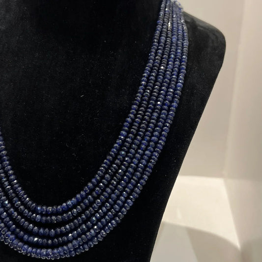 A multi-strand 6 layer blue sapphire beads necklace displayed on a black mannequin bust.