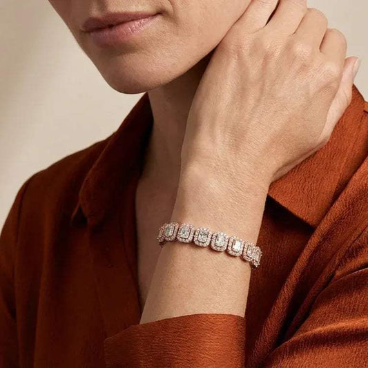 Close-up of a person wearing a real diamond bracelet on a neutral background.