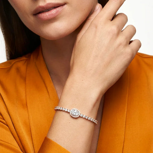 Close-up of a woman's hand wearing a real diamond bracelet on an orange background