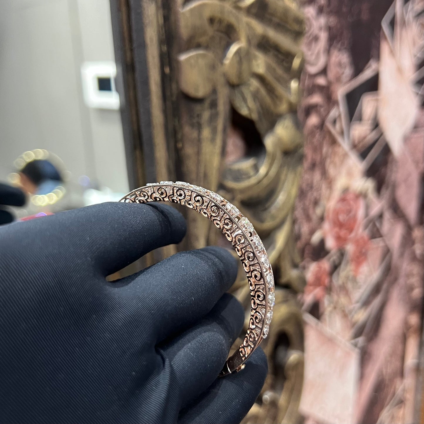 Elegant gold diamond bracelet with round-cut diamonds in a bangle design, displayed on a hand.