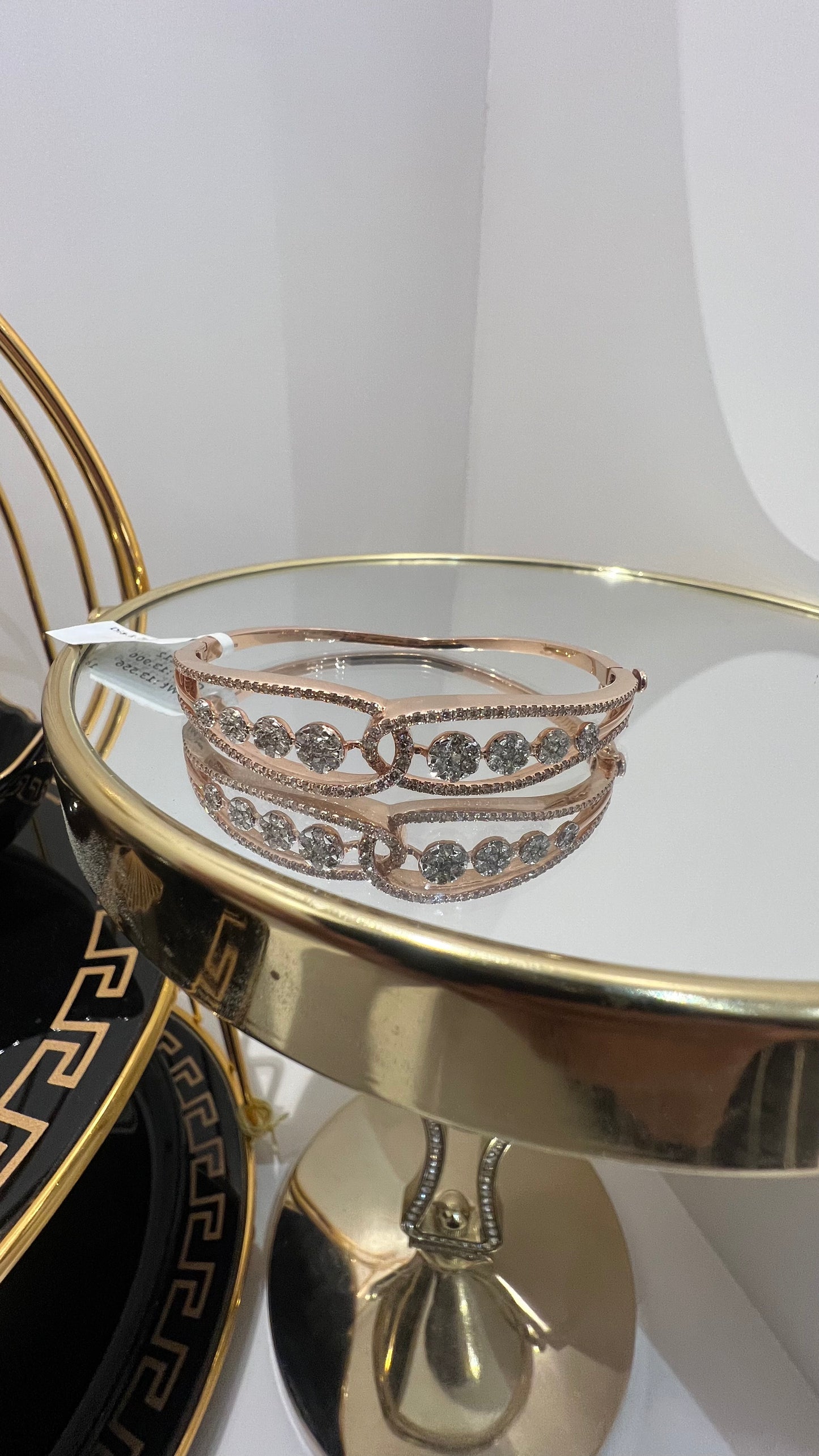 Gold diamond bracelet with round brilliant cut diamonds in chain-link bangle design displayed on luxury background.