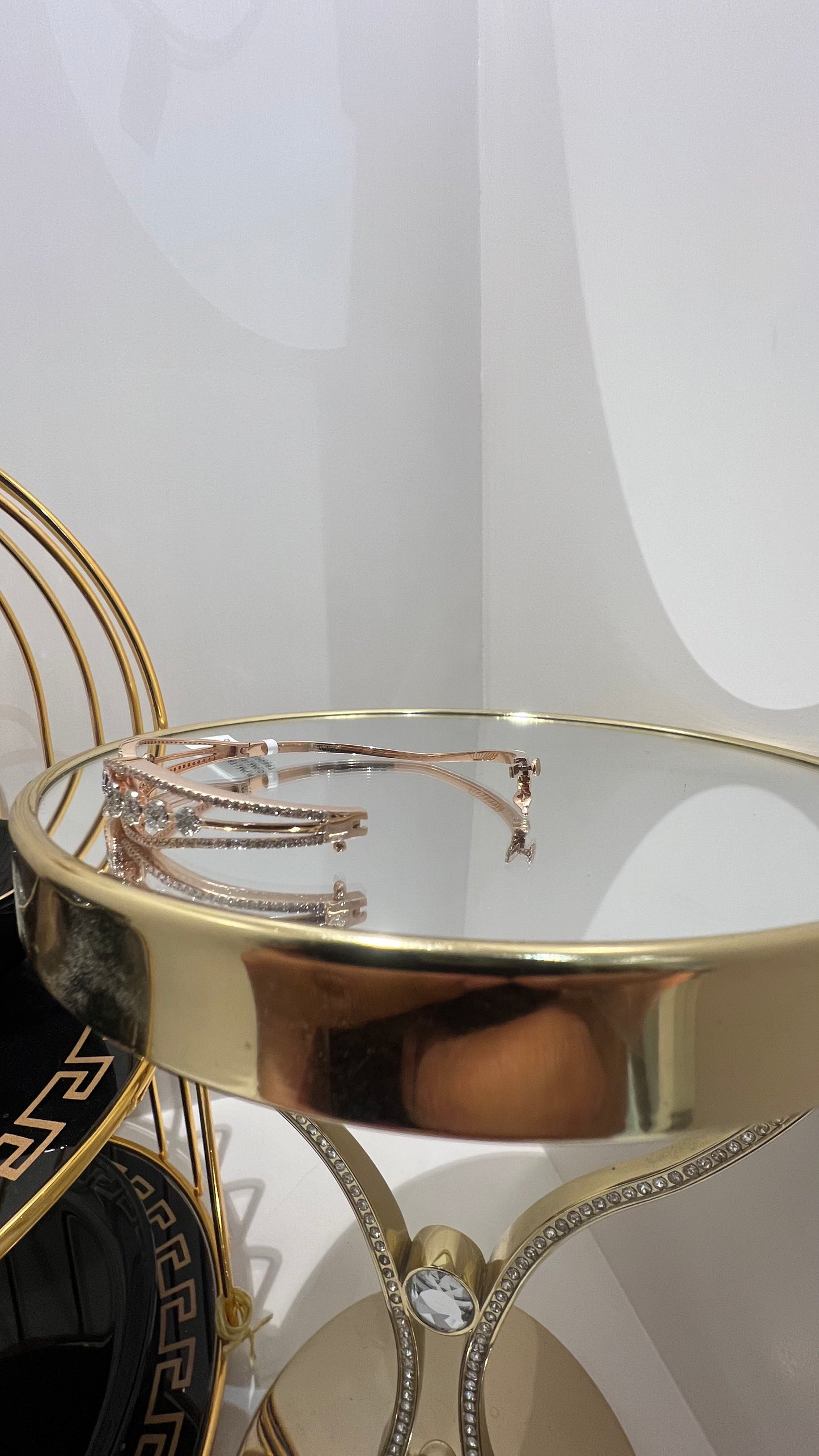 Gold diamond bracelet with round brilliant cut diamonds in chain-link bangle design displayed on luxury background.