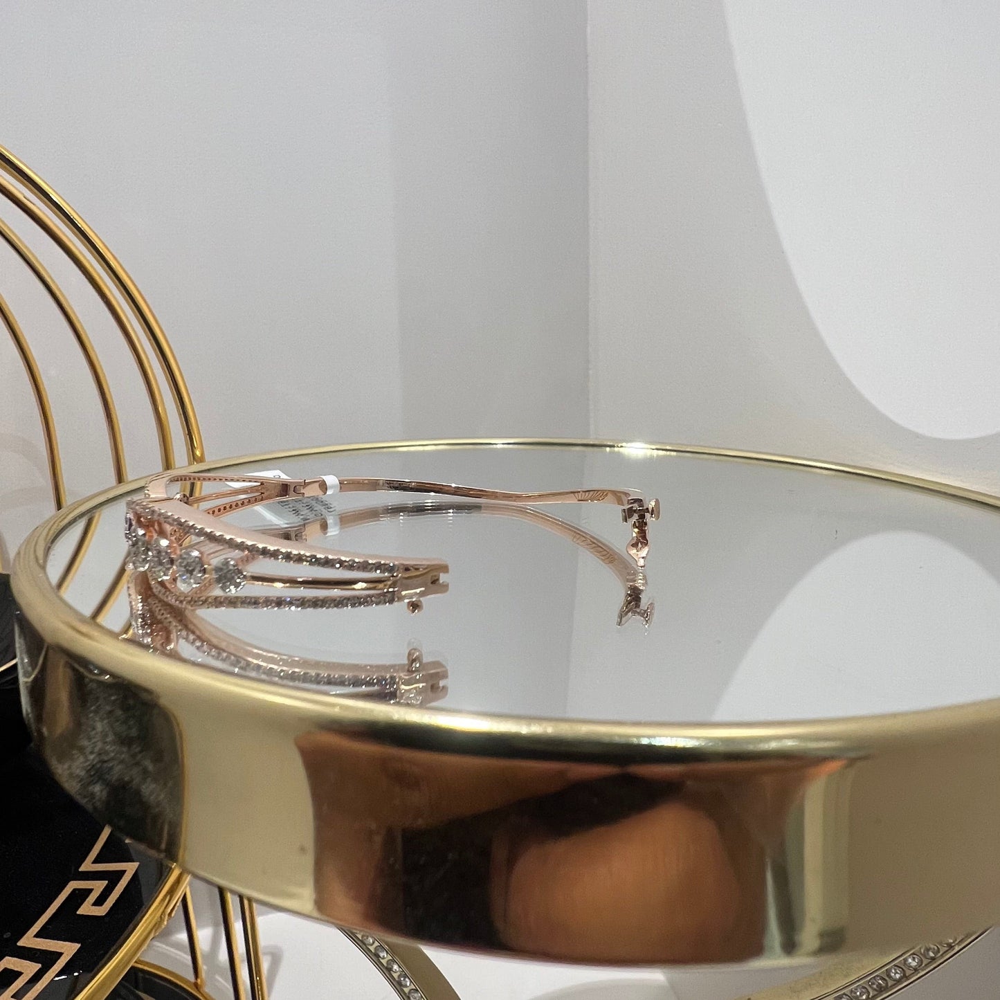 Gold diamond bracelet with round brilliant cut diamonds in chain-link bangle design displayed on luxury background.