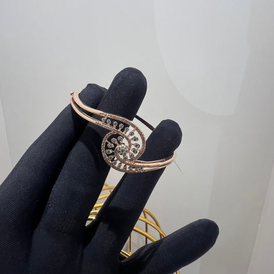 A luxurious gold diamond bracelet with a openable design, featuring a central oval-shaped diamond surrounded by smaller diamonds set in a brilliant cut, displayed on a mannequin hand.