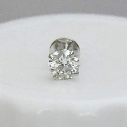 Round solitaire diamond stud earring on a light gray background