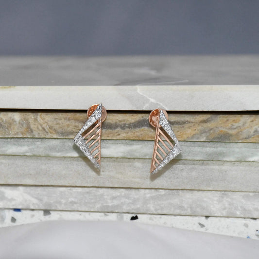 Pair of gold and diamond geometric earrings on a marble surface.