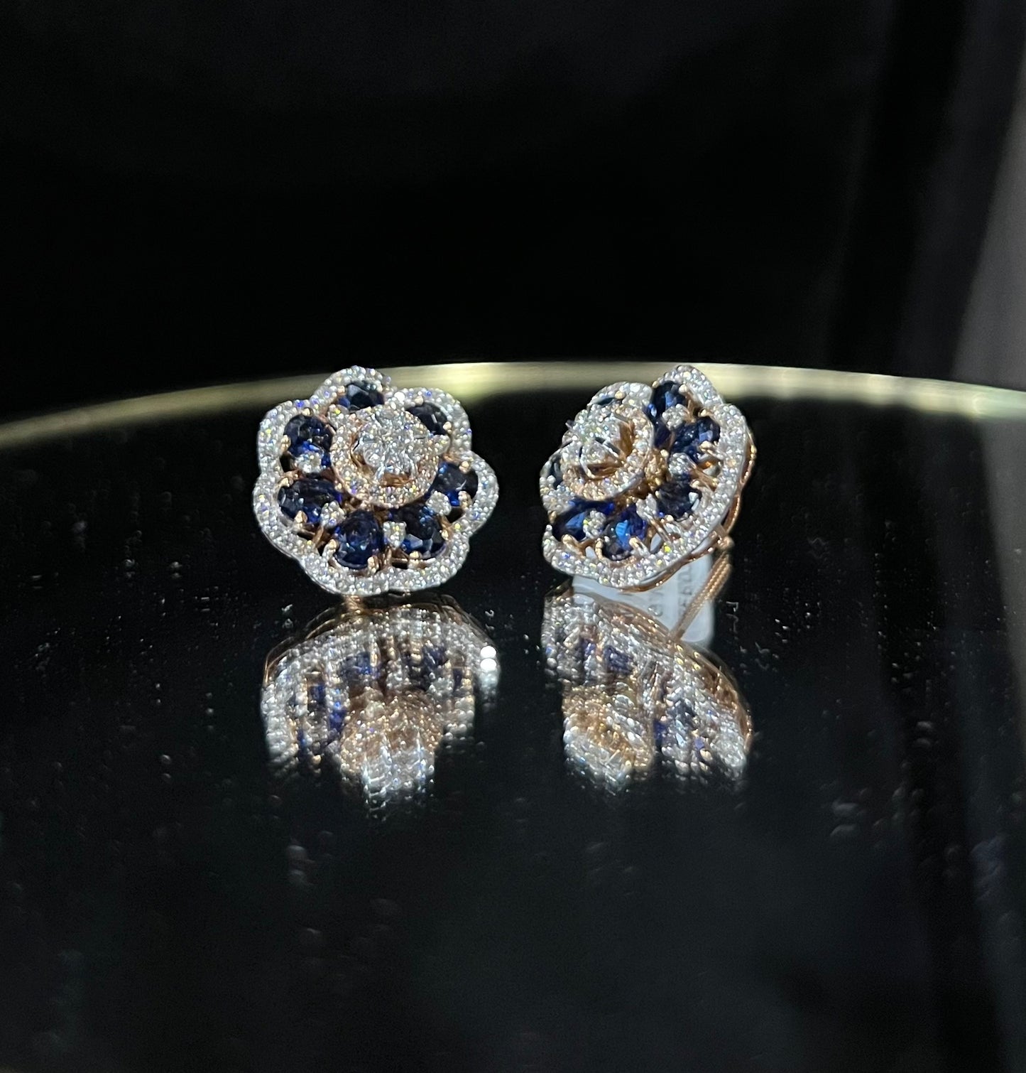 Close-up of natural blue stone and diamond earrings in a floral stud design, crafted in gold – elegant women’s diamond earrings.