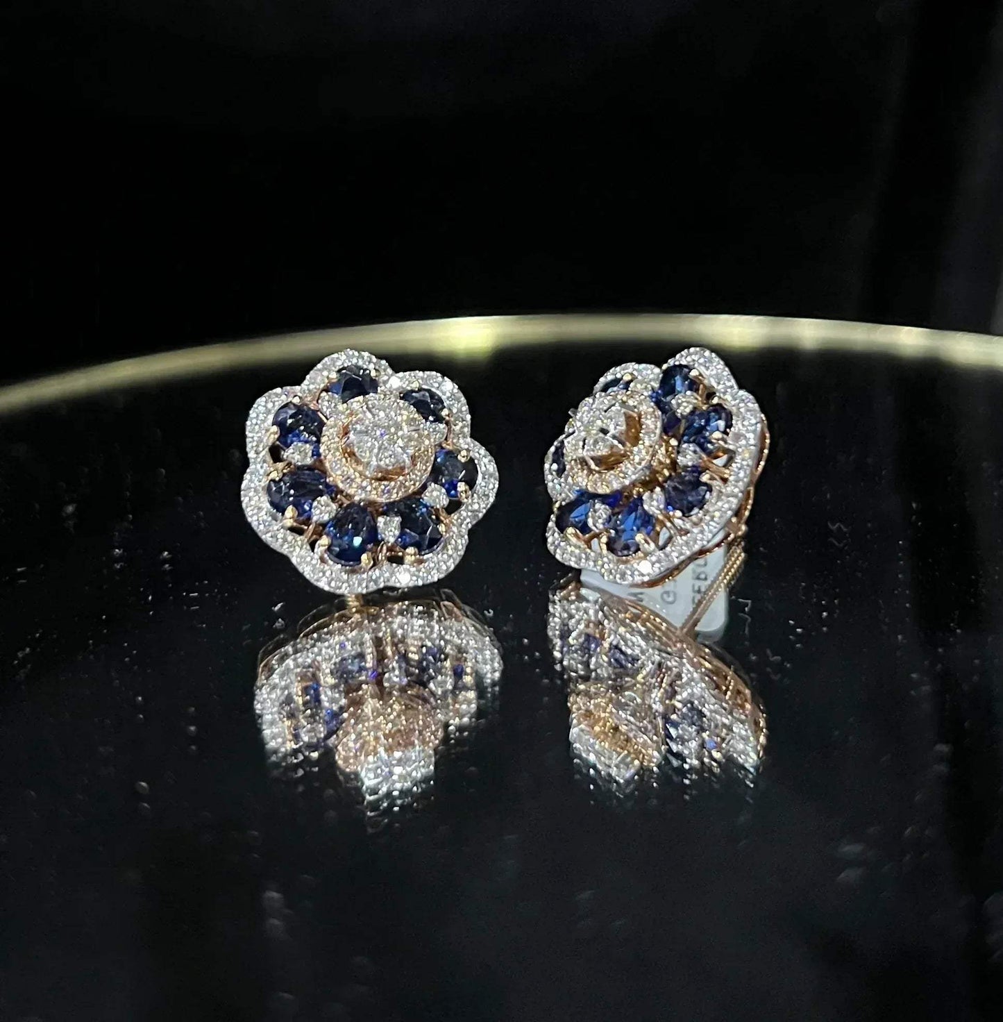 Close-up of natural blue stone and diamond earrings in a floral stud design, crafted in gold – elegant women’s diamond earrings.