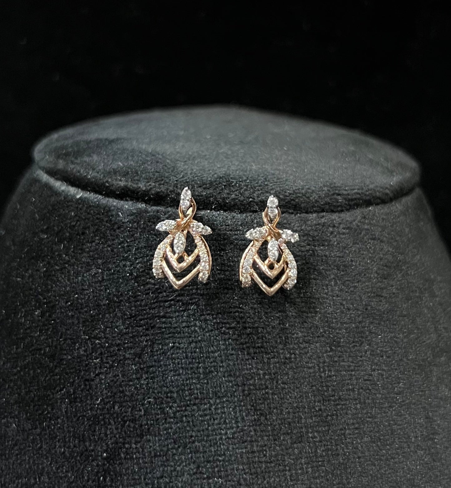 A pair of diamond earrings with a rose gold or gold color finish, featuring a V-shaped design with diamond embellishments.