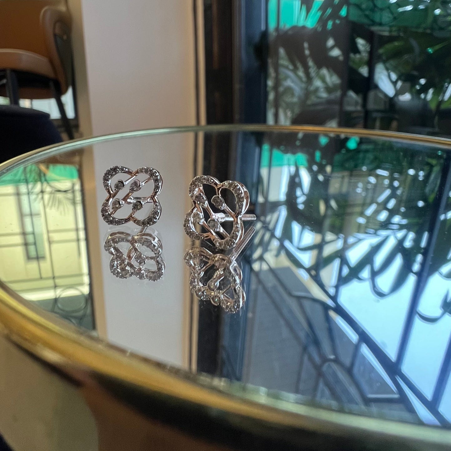 view of clover bloom diamond earrings in gold with openwork floral design and sparkling diamonds.