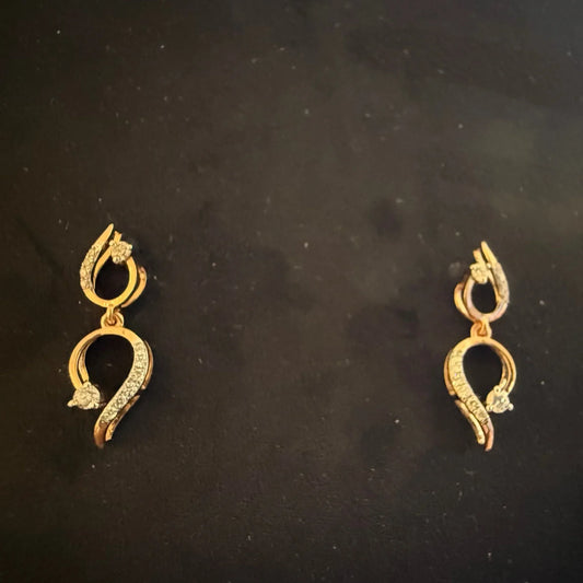 A gold diamond earrings with a chain link design, displayed on a mannequin bust.