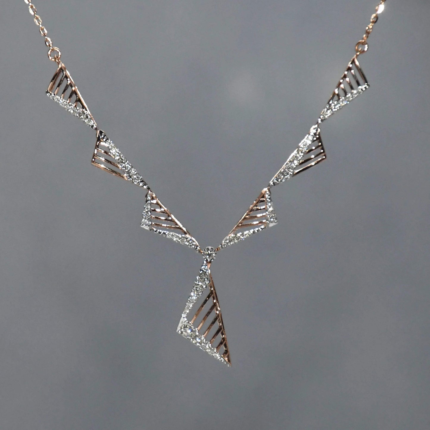 diamond necklace with geometric design on a gray background