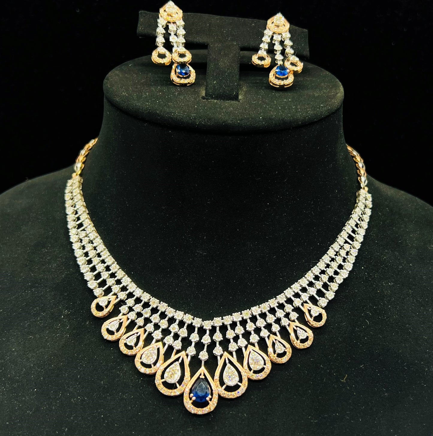 A gold bridal diamond necklace with round-cut beauty displayed on a mannequin bust.