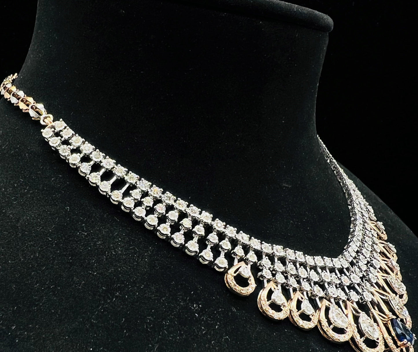 A gold bridal diamond necklace with round-cut beauty displayed on a mannequin bust.