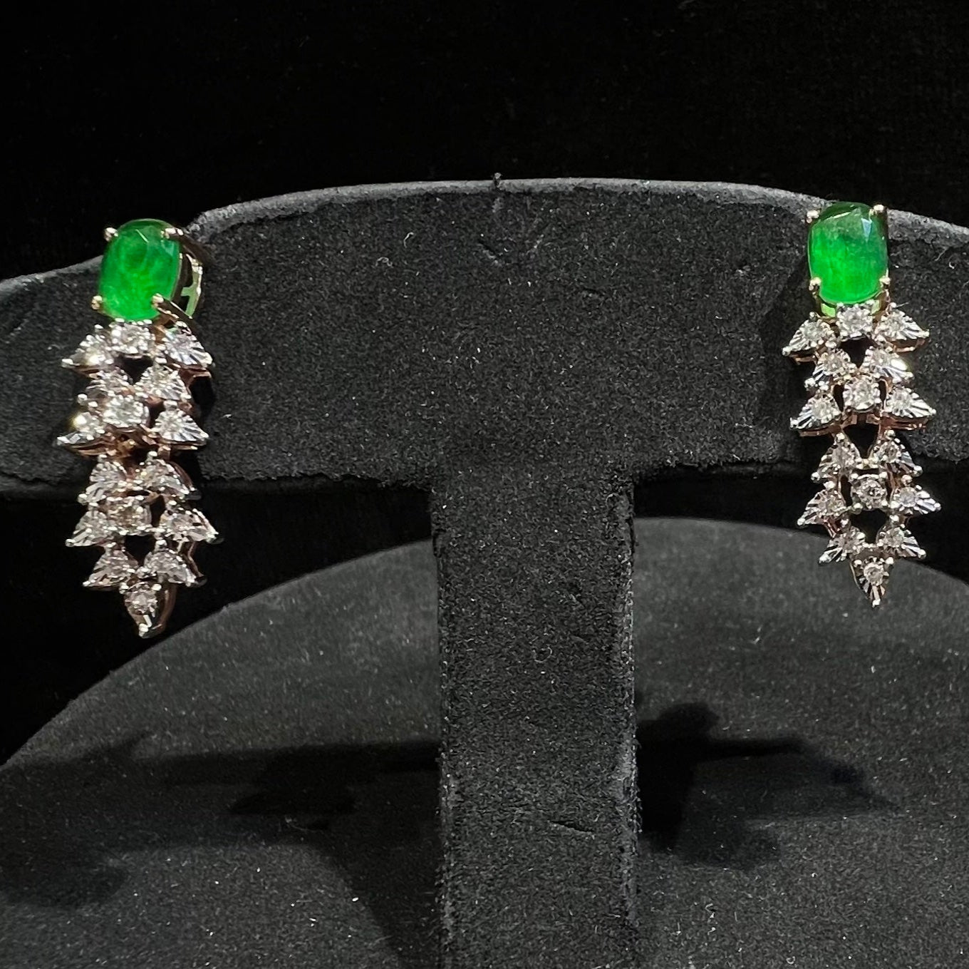 Designer diamond color stone earrings displayed on a mannequin bust.
