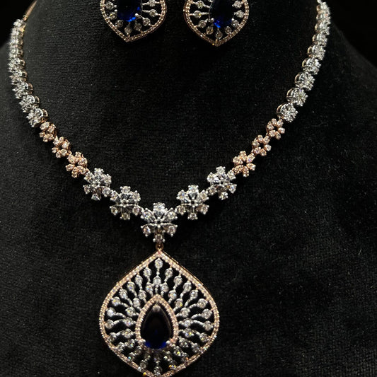 Floral design diamond necklace set with matching earrings, featuring a pear-shaped blue stone drop surrounded by natural diamonds.