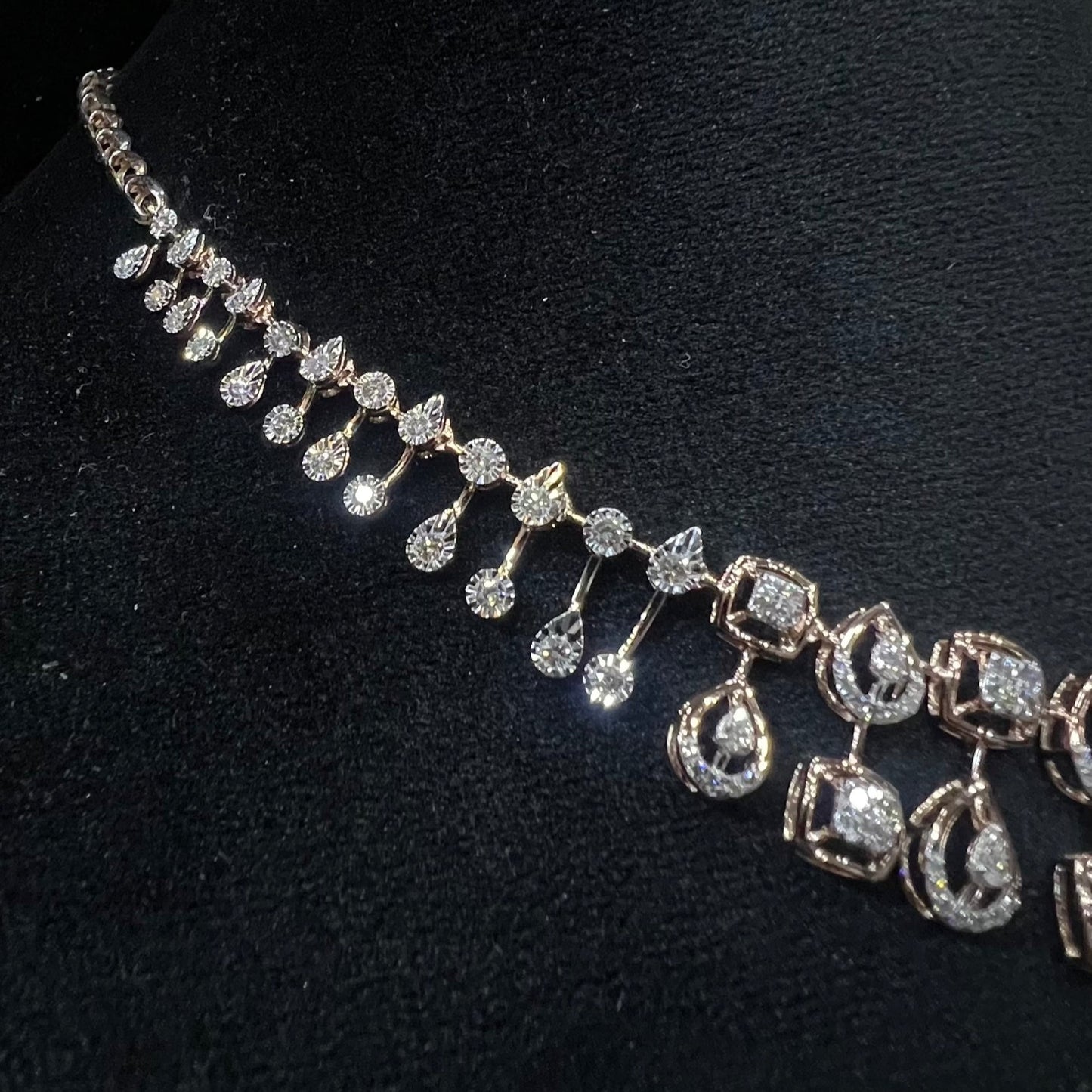 A gold diamond necklace is displayed on a mannequin bust