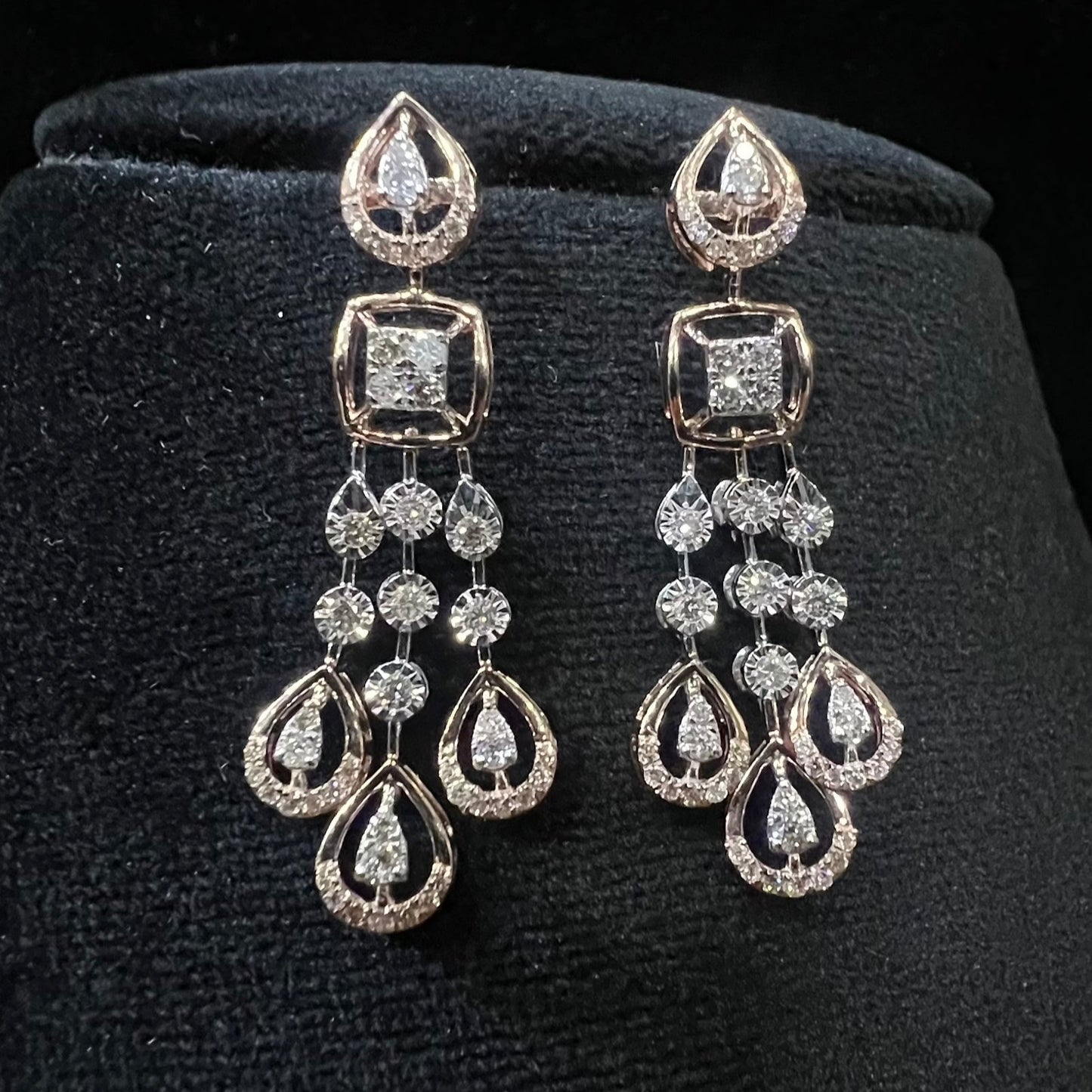 gold diamond earrings set displayed on a mannequin bust, featuring a solid gold structure with diamond encrusted in the earrings.