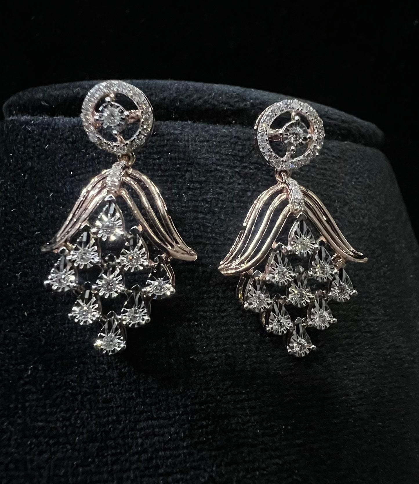 Radiant cascade diamond earrings displayed on black velvet bust