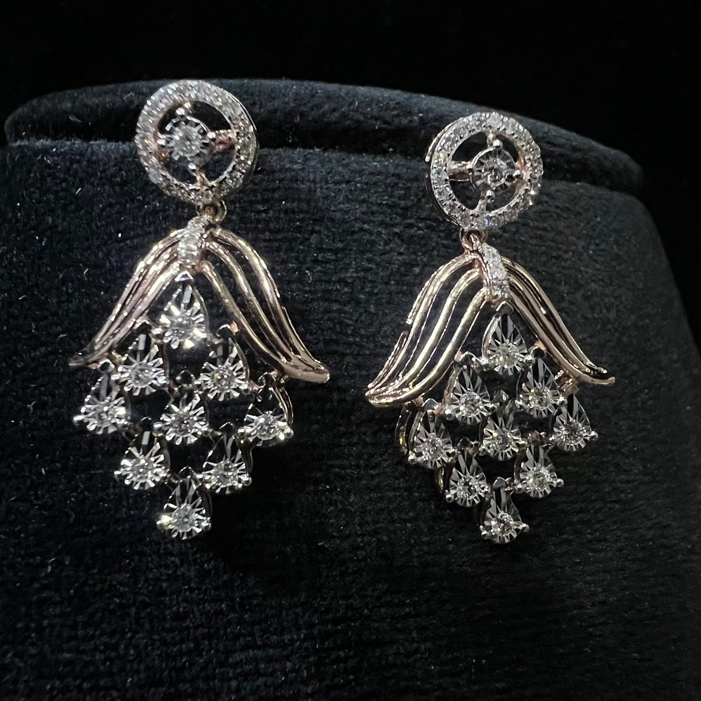 Radiant cascade diamond earrings displayed on black velvet bust