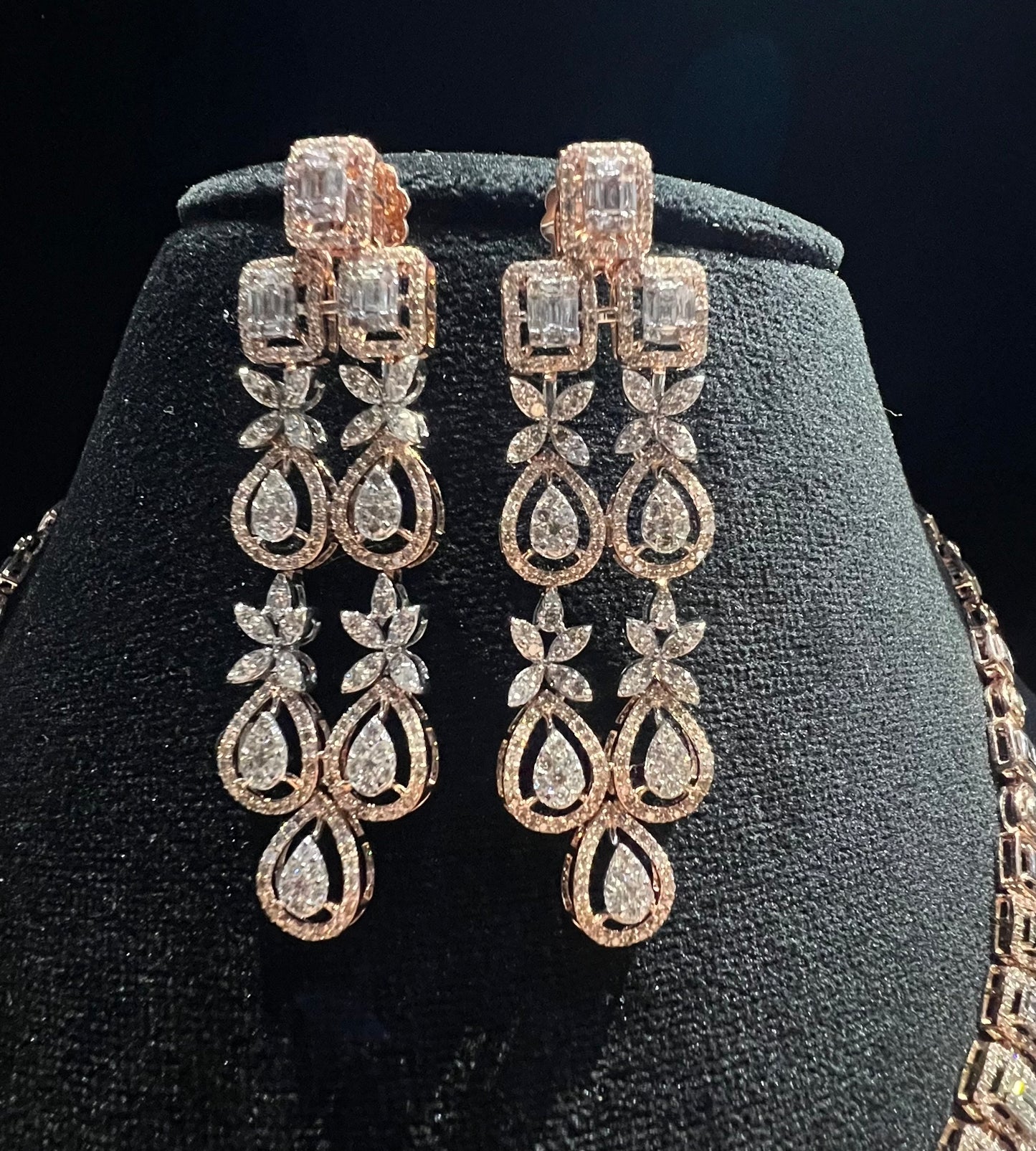 Luxury floral motif diamond necklace set with matching drop earrings on a mannequin bust.