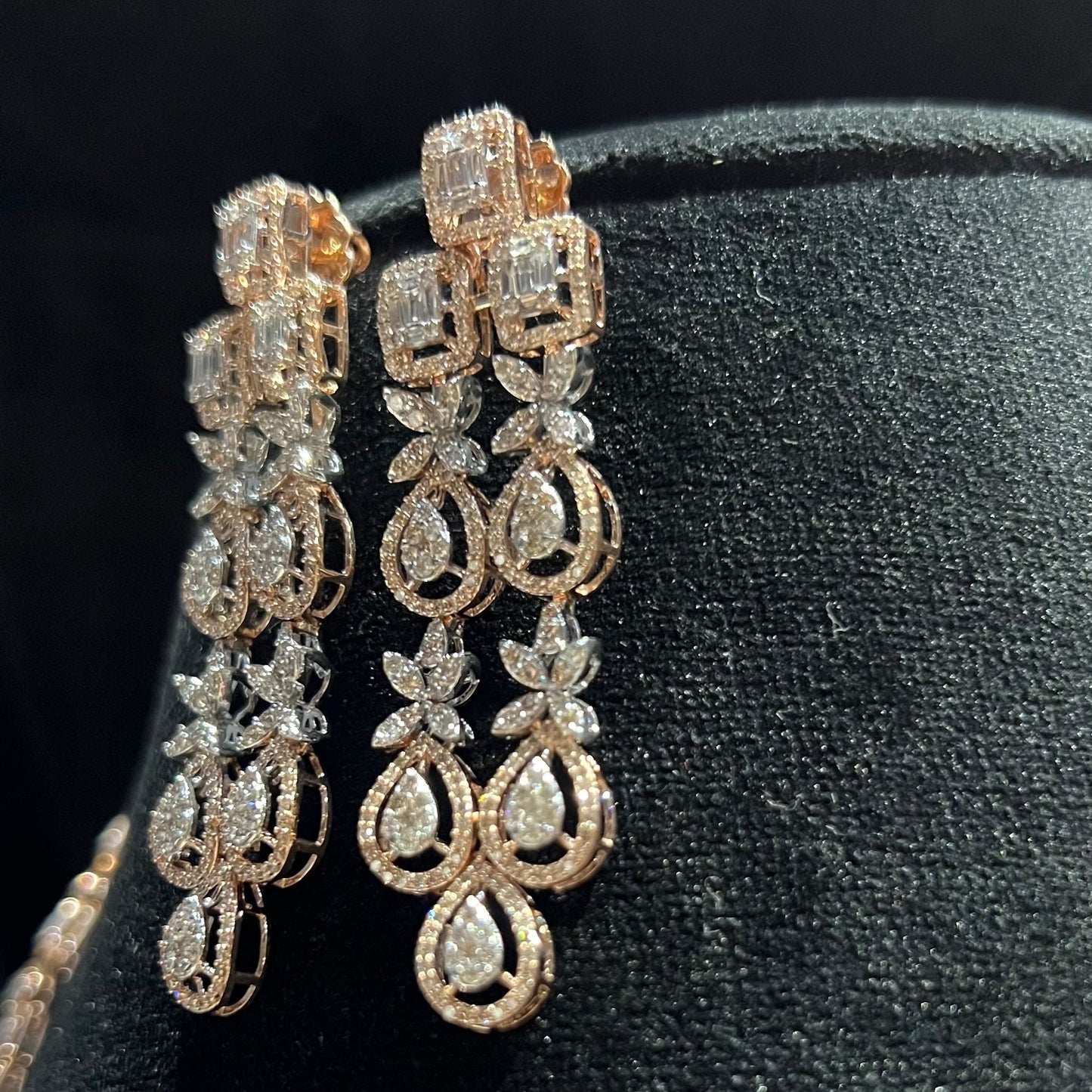 Luxury floral motif diamond drop earrings on a mannequin bust.