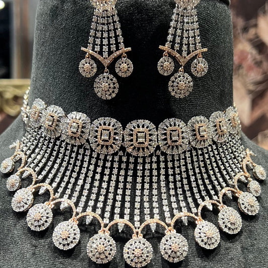 A gold diamond choker necklace with a matching set of earrings, adorned with brilliant cut diamonds, displayed on a mannequin.