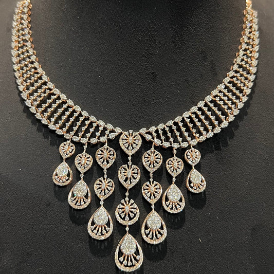 A gold diamond necklace with a geometric pattern and a pair of matching earrings, displayed on a mannequin bust.