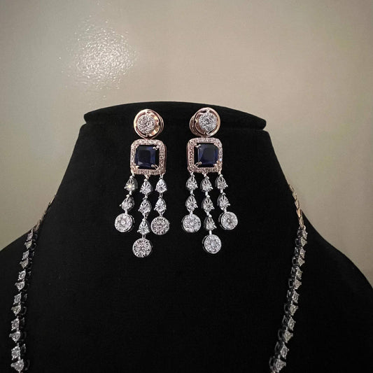 A gold diamond necklace with a matching set of earrings, featuring a series of round and marquise shaped diamonds set in a classic design on a mannequin bust.
