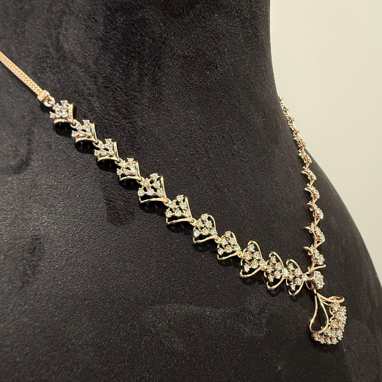 A luxurious gold diamond necklace with earrings set, displayed on a mannequin bust.