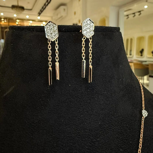 Modern diamond necklace set with hexagon pendant and matching drop earrings on display.