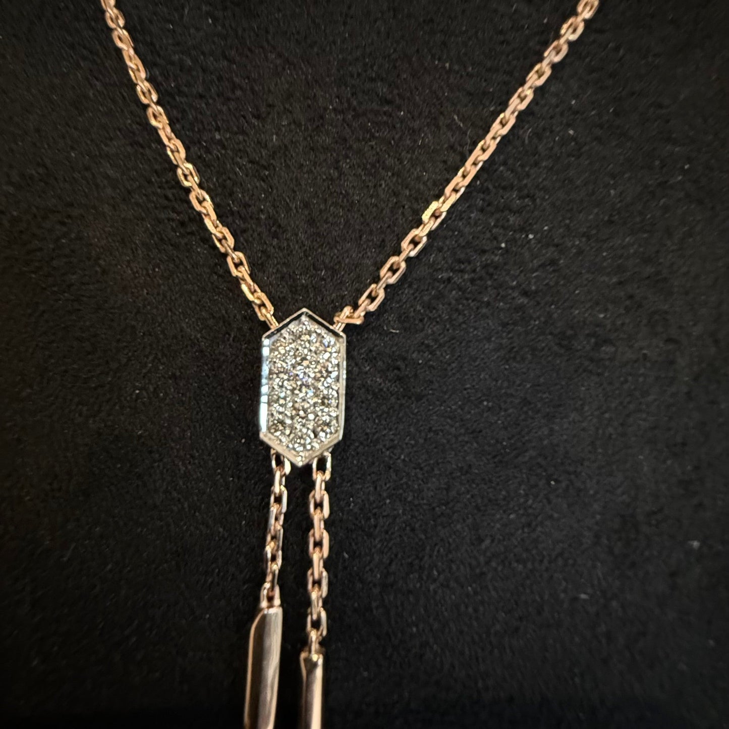 Modern diamond necklace set with hexagon pendant on display.
