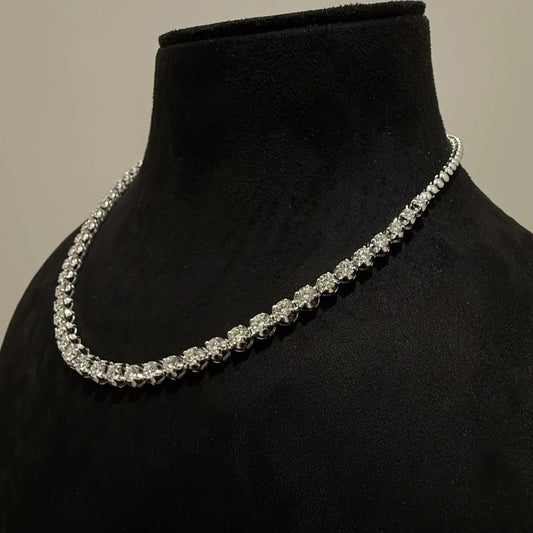Elegant round cut diamond necklace set displayed on a black mannequin stand.