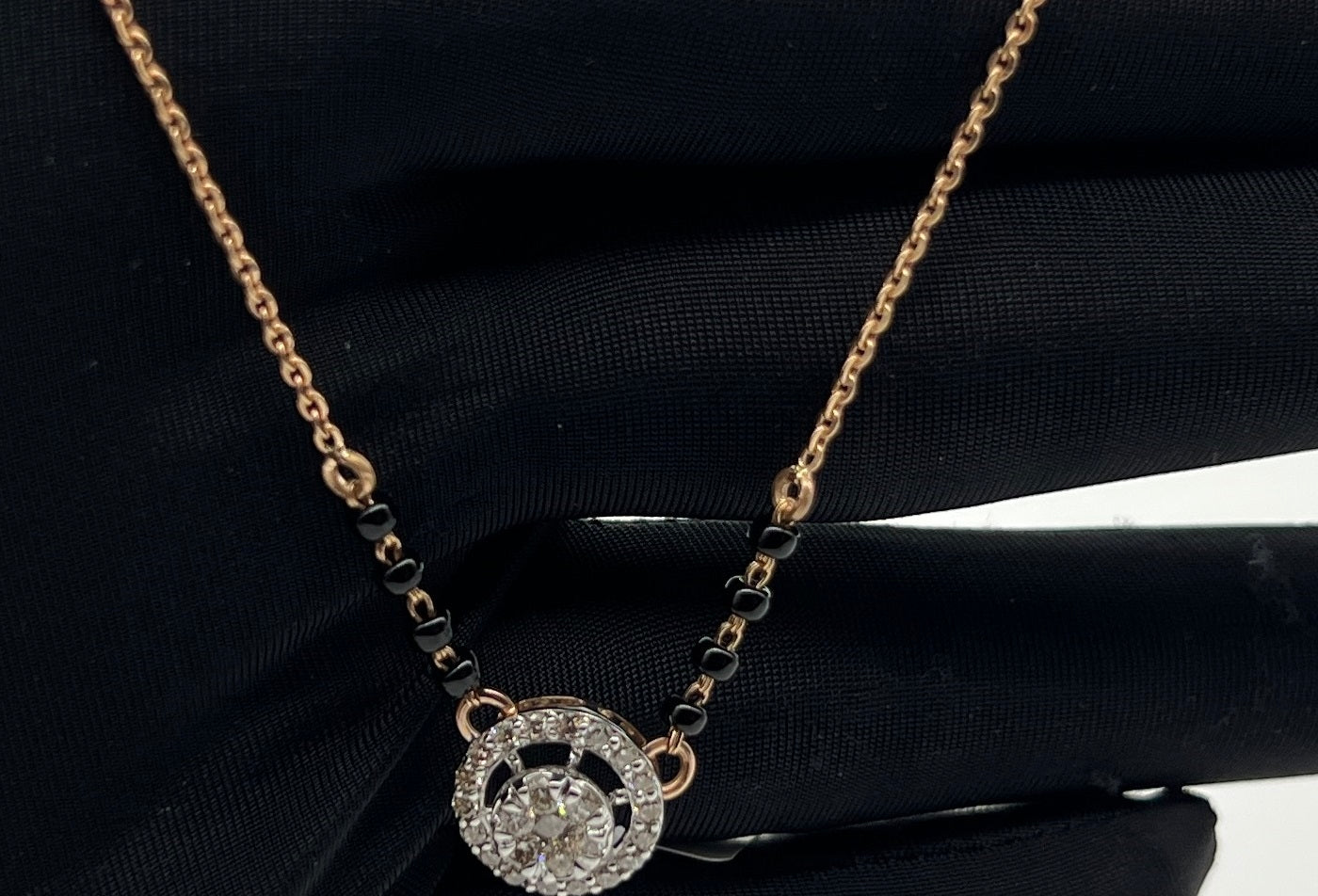 Elegant gold diamond mangalsutra with round halo diamond pendant and dual black bead gold chain, perfect for daily wear and modern bridal style.