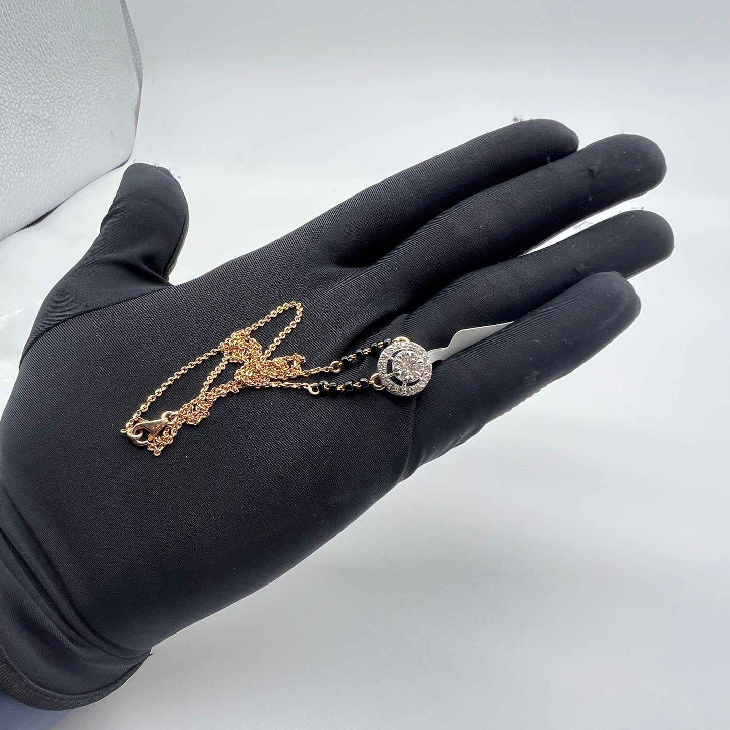 Elegant gold diamond mangalsutra with round halo diamond pendant and dual black bead gold chain, perfect for daily wear and modern bridal style.