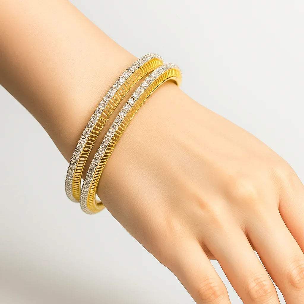 Gold and lab grown diamond bangles on a hand against a light gray background