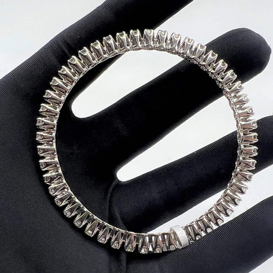 White gold ring with lab grown diamond on a black glove.