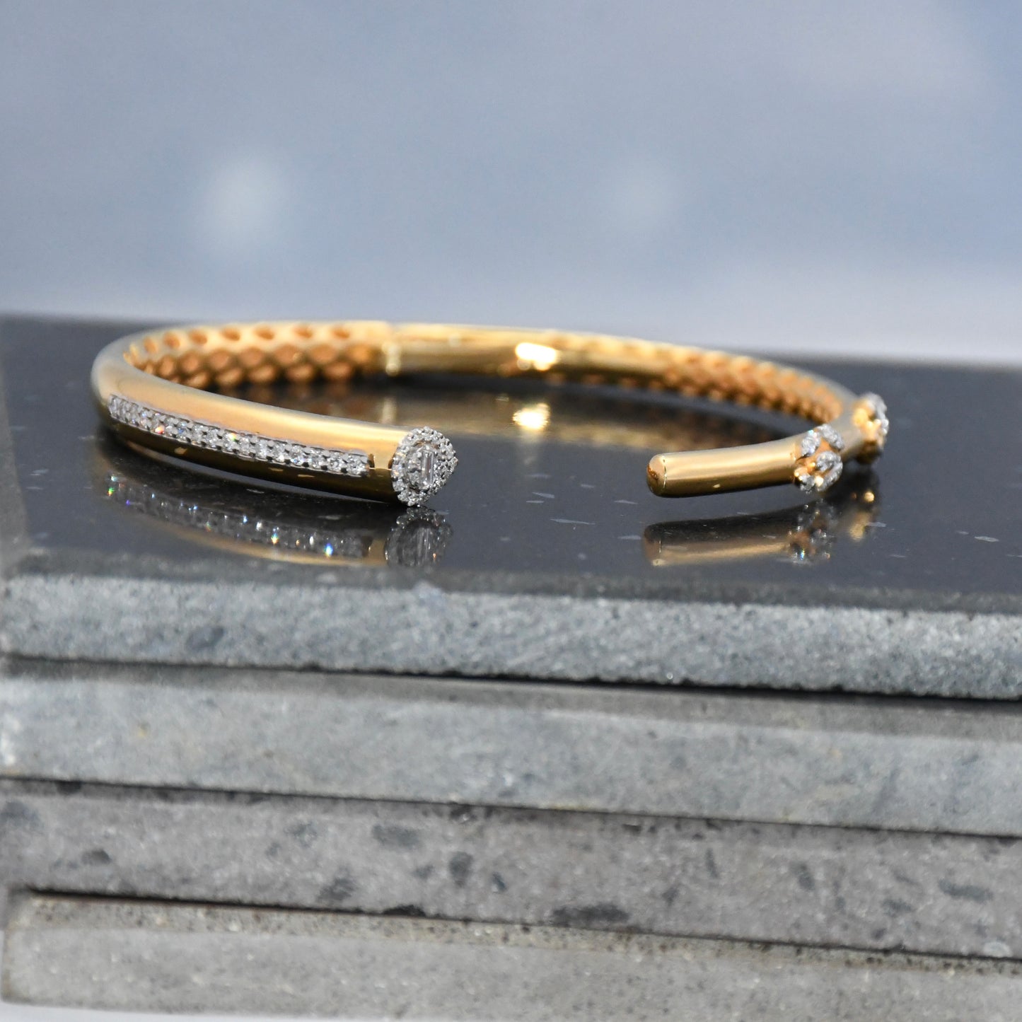 Gold bracelet with small lab grown diamonds on a dark surface