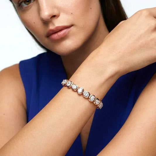 Woman wearing a rose gold bracelet with lab grown diamonds on a white background