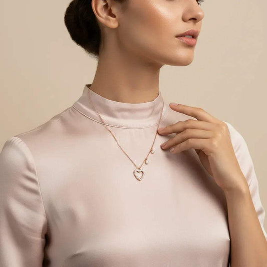 Woman wearing a delicate lab grown diamond necklace with a heart pendant on a beige background