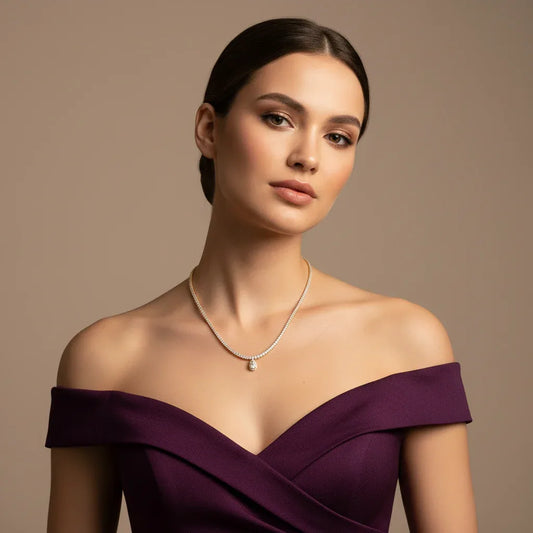 Woman wearing a purple off-shoulder dress and lab grown diamond pendant tennis necklace against a beige background