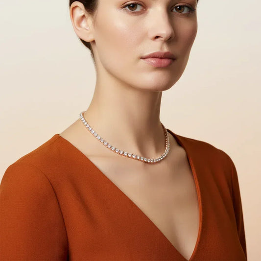 Woman wearing a lab grown diamond tennis necklace with a plain background