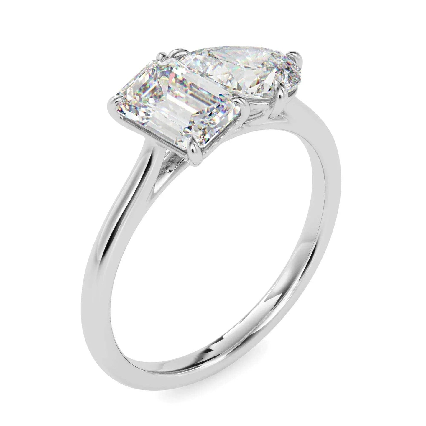 White gold ring with two lab grown diamonds- one pear shape and other baguette shape, on a white background.
