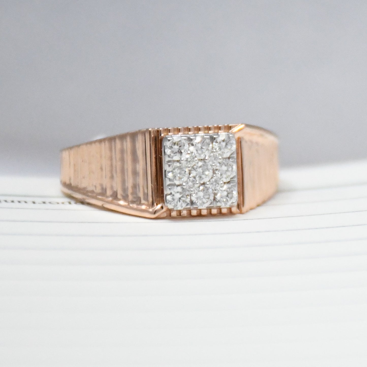 gold ring with diamonds on a light gray background