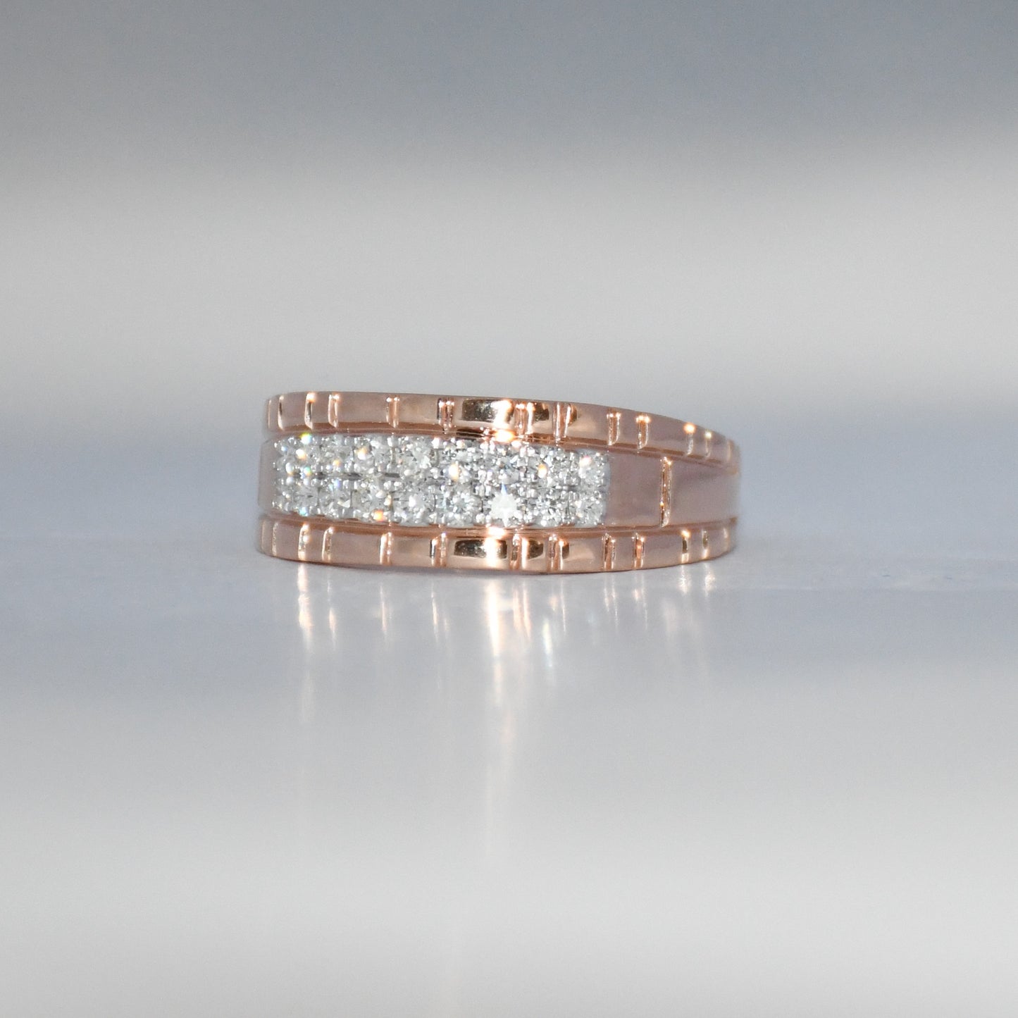 gold ring with embedded diamonds on a reflective surface