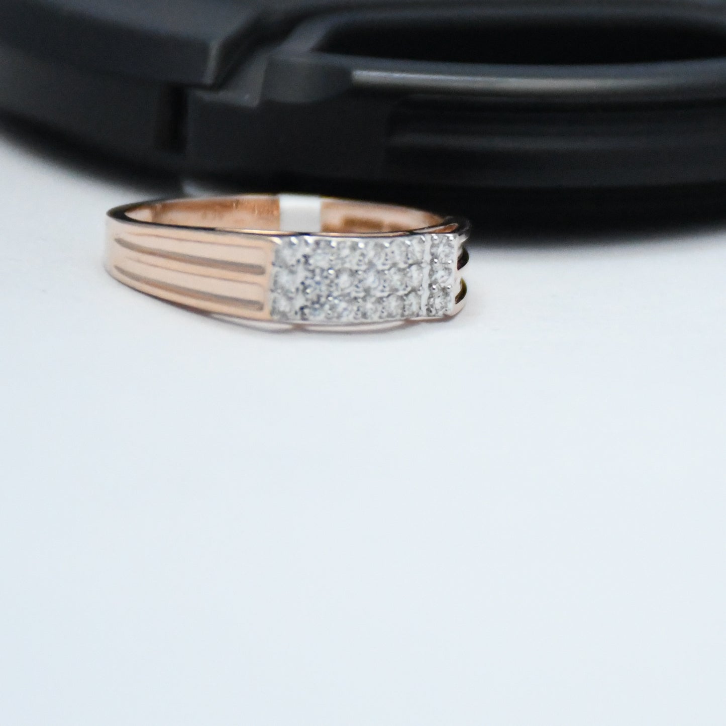 Rose gold ring with diamond accents on a white surface