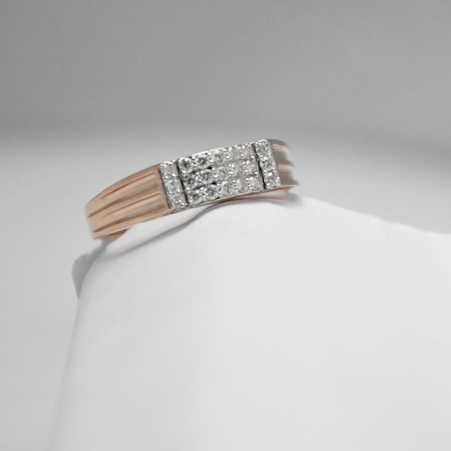 men's diamond ring with a gold band on a white mannequin arm against a gray background