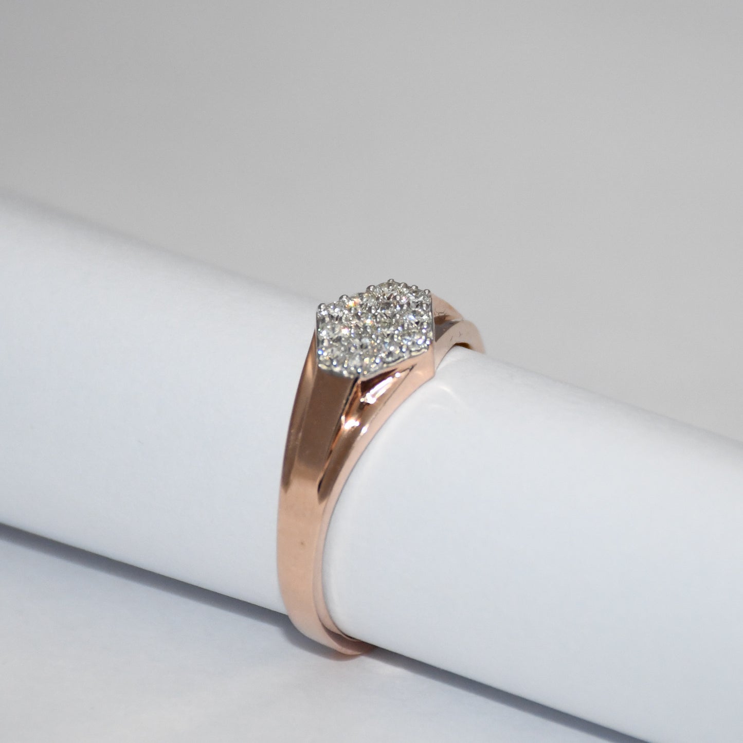 gold ring with a diamonds cluster on a white surface
