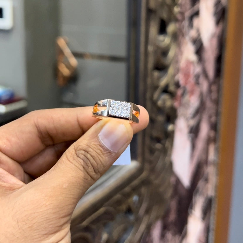 A man's hand displaying a diamond ring with a gold band.