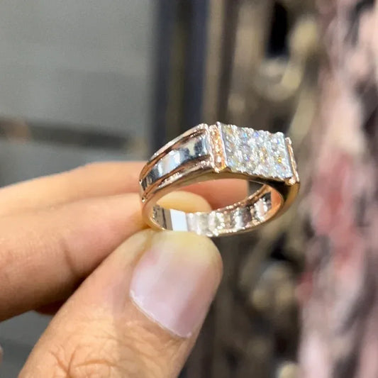 Men’s diamond ring in dual-tone gold with bold rectangular cluster of round diamonds at the center, flanked by sleek metal panels, shown worn on finger.